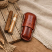 CigarVault калъф за две пури затворен под ъгъл – Full Grain кожа, бял седларски шев, пури на дъска