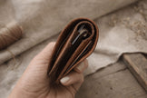 Компактен портфейл с монетник Nest кафяв в ръка